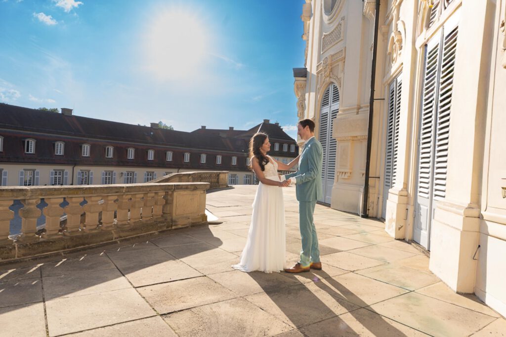 Brautpaar vor dem Residenzschloss Ludwigsburg im Gegenlicht der untergehenden Sonne – emotionale Hochzeitsfotografie.